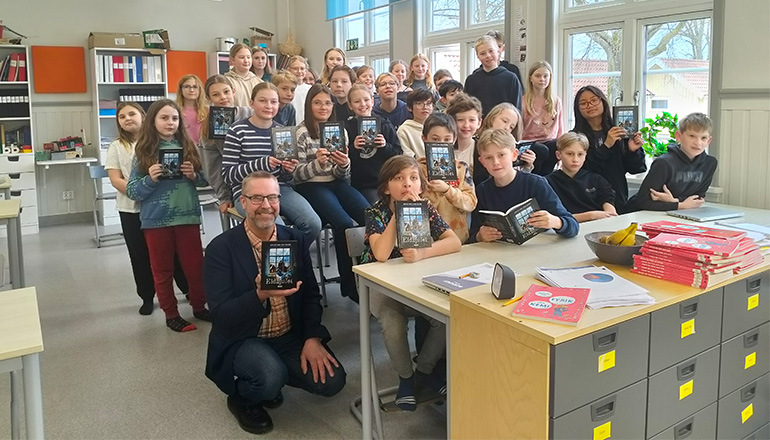 Skolklass som håller i böcker