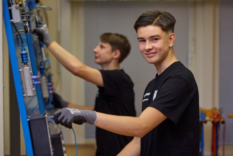 Två elever som står i elsalen och håller i olika elinstrument. 